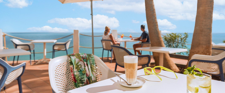 Blick von einem Tisch auf der Terrasse des Playa de Esquinzo auf Fuerteventura über andere Tische direkt aufs Meer.